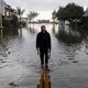 A resident walks along a flooded street after a rainstorm in the northern California town of Aptus on Jan. 5, 2023.